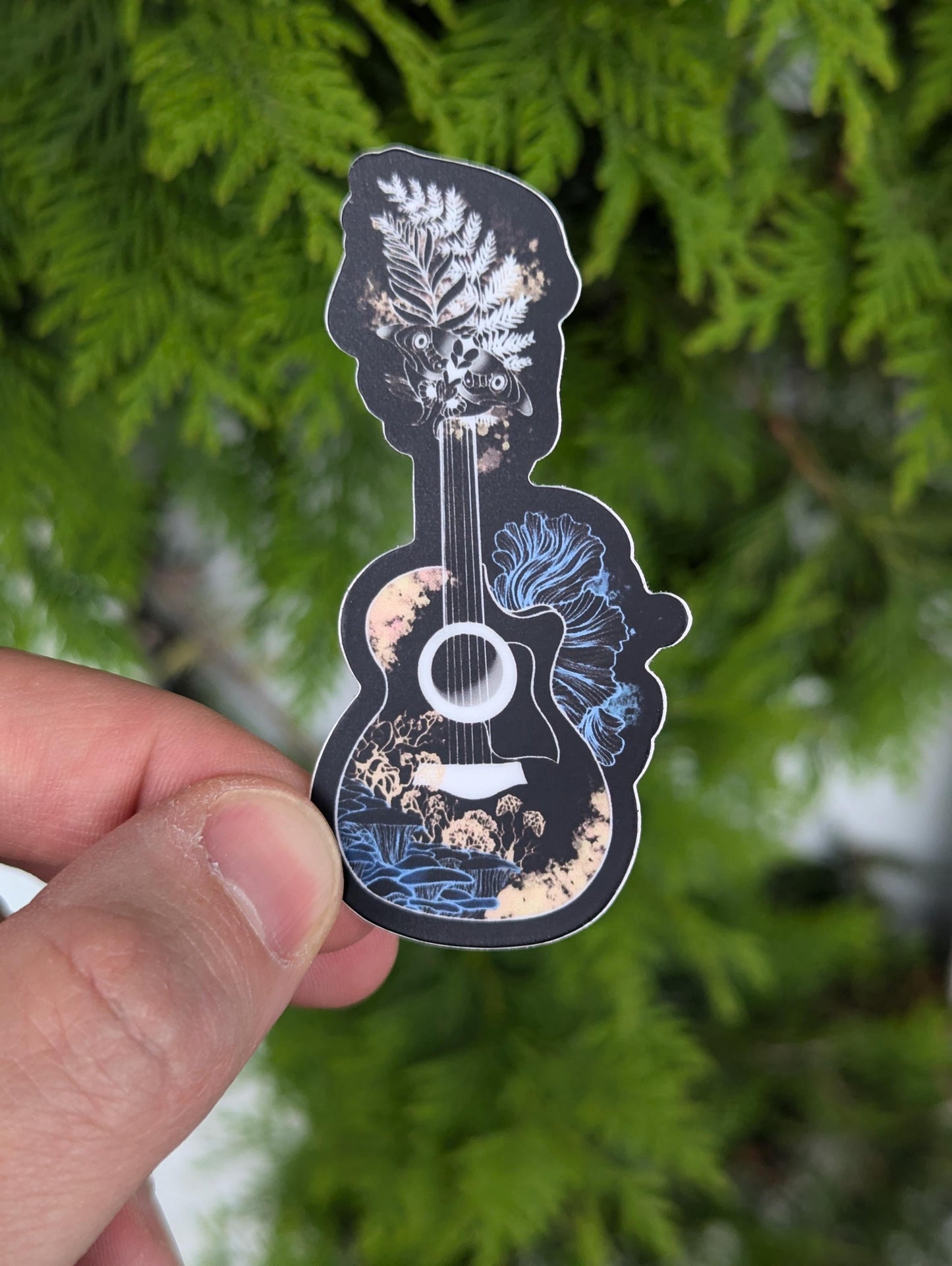 Vinyl sticker fan art of Joel & Ellie's guitar from the Last of Us (TLOU). Guitar is outlined in white and has cordyceps mycella around it. Neck of guitar is replaced by Ellie's tattoo.